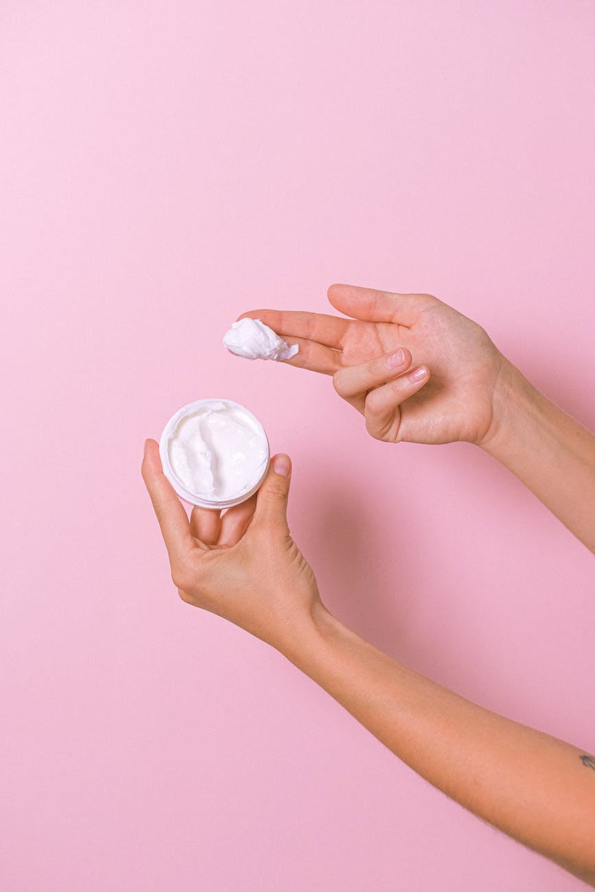 crop person with smear of face cream